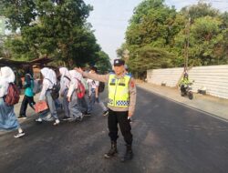 “Polisi Bantu Keselamatan Masyarakat, Anak Sekolah Menyeberang Jalan di Depan SMKN 1 Palasah”